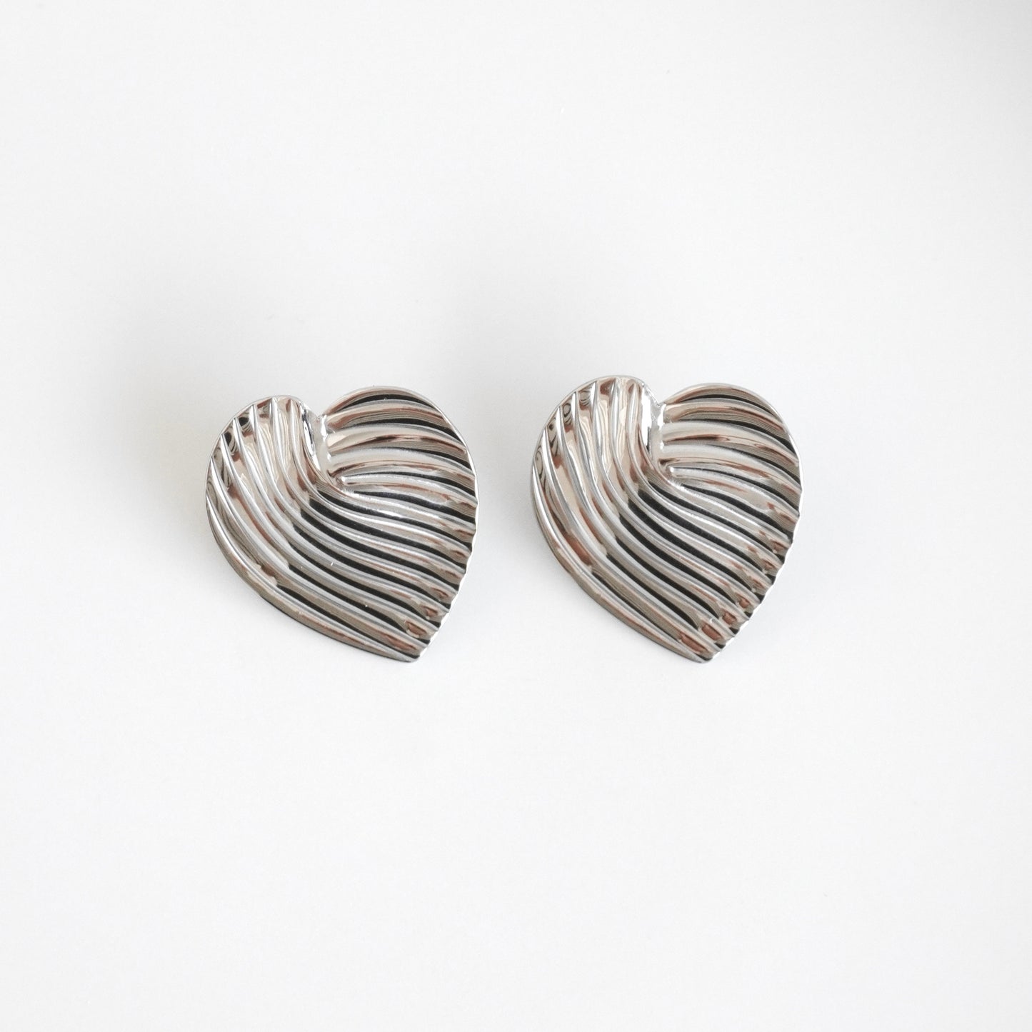 Aretes tipo corazón con líneas plateados