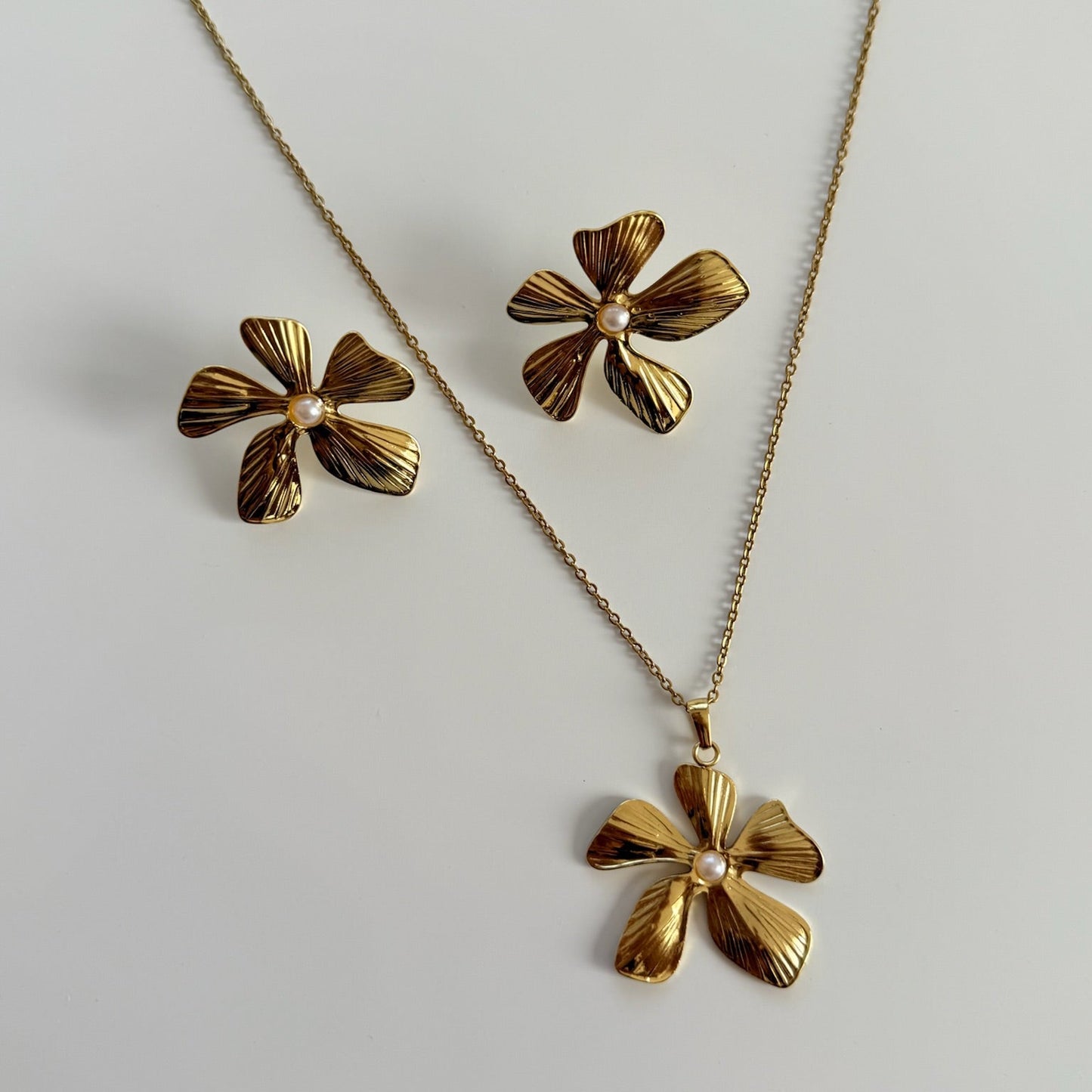 Set de cadena y aretes flor asimetrica